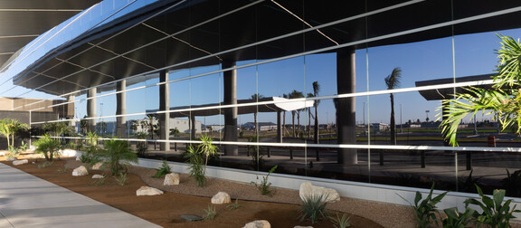 Exterior of building with custom smart glass windows and greenery.