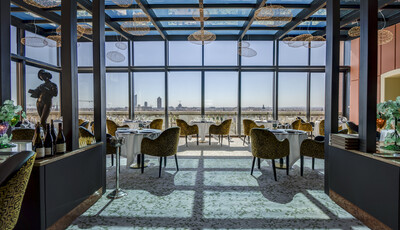 Interior of restaurant with unique dining space and custom smart glass windows overlooking the city.