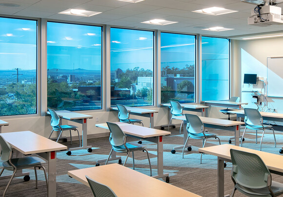 Classroom with individual desks and smart glass windows overlooking the town. 